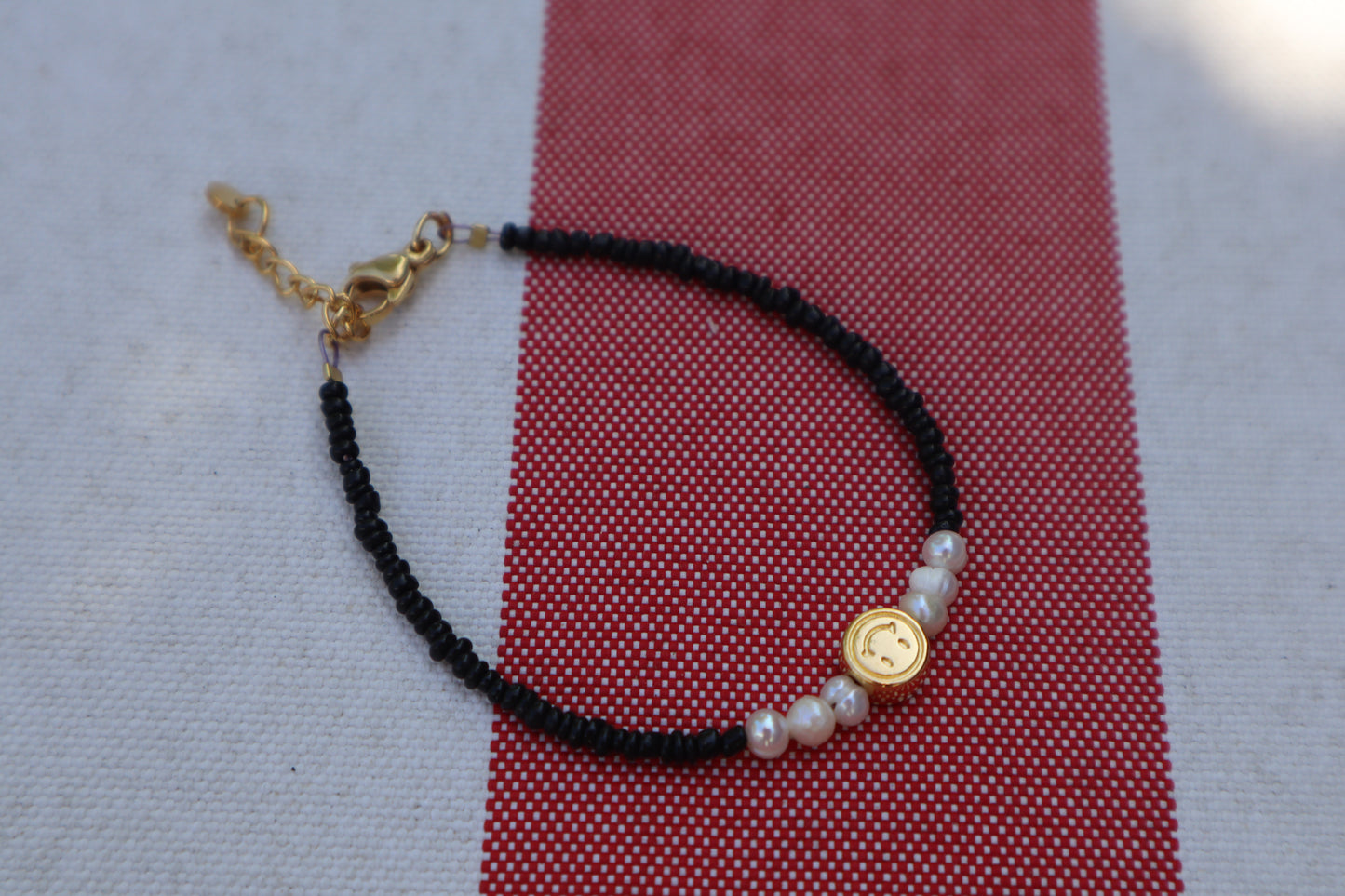 Armband: gouden smiley - zwart